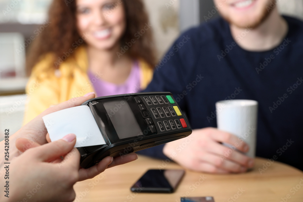 Clients using credit card machine for non cash payment in cafe, closeup Clients using credit card machine for non cash payment in cafe, closeup