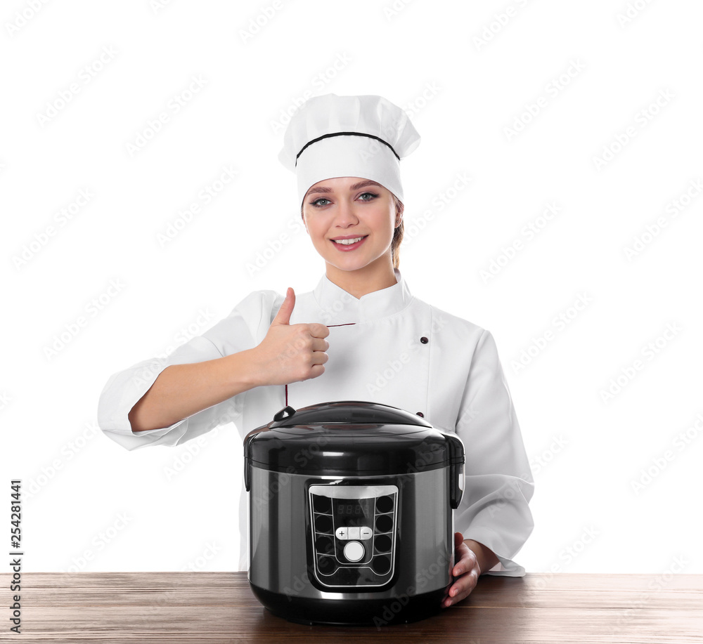 Female chef with modern multi cooker at table against white background Female chef with modern multi cooker at table against white background