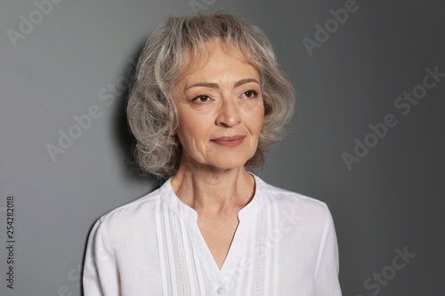 Portrait of mature woman on grey background