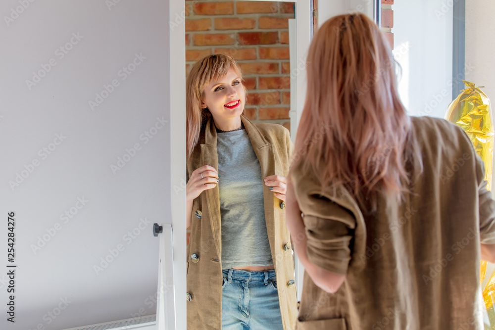 woman dressing up near mirror at home. woman dressing up near mirror at home.