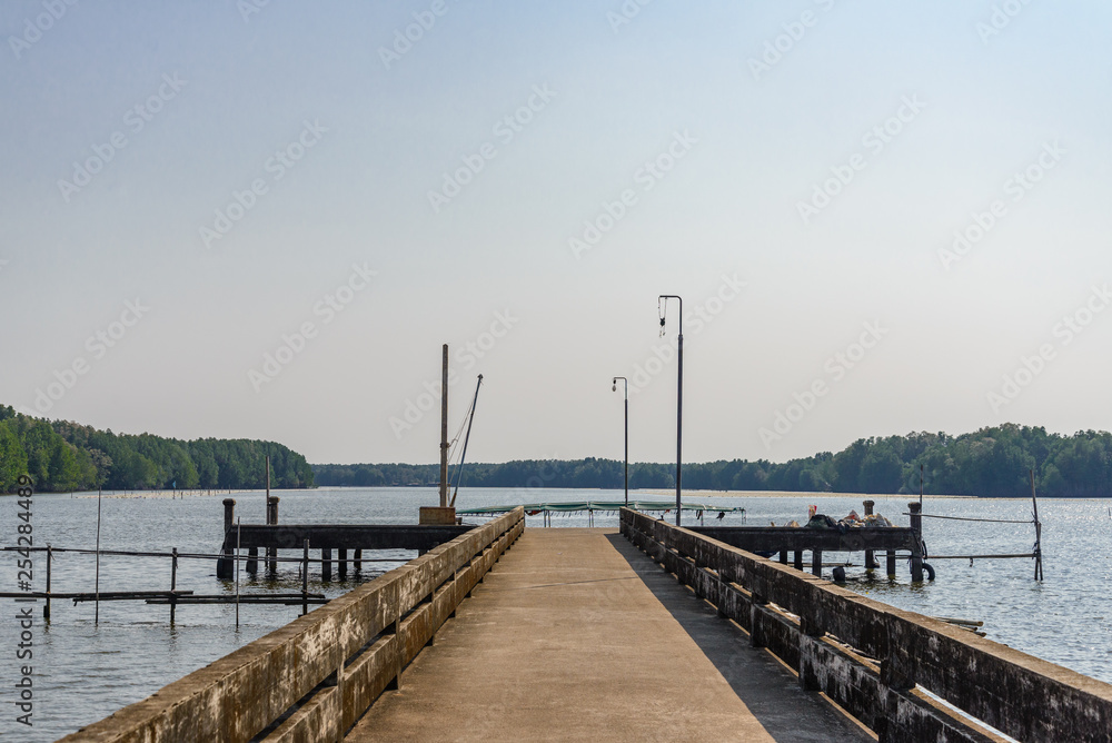 Sunny outdoor view of concrete pier at retreat and tranquil area in small village and surrounded with mangrove forest  in Chanthaburi, Thailand.