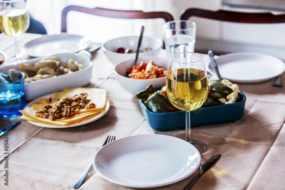 glass of wine and dishes on table in dinner time glass of wine and dishes on table in dinner time