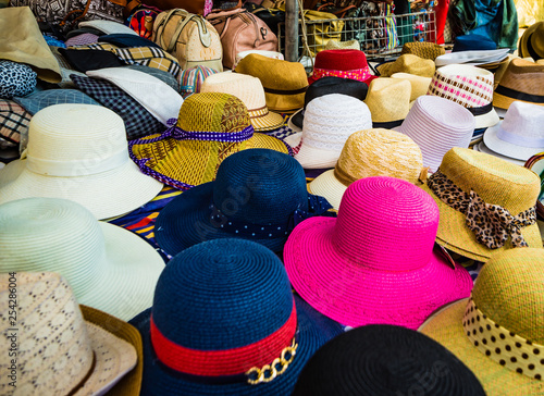 Variety of hats for women in a market in the old town of Ortigia in Syracuse.