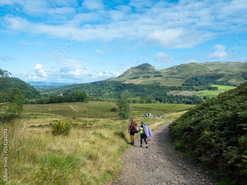 two girls hiking in sunny weather in scotland © iris