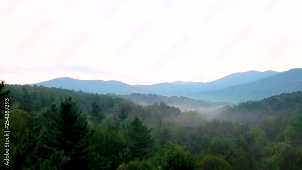 Flying over morning mountain range with mist and sunrise in background. Flying over morning mountain range with mist and sunrise in background.