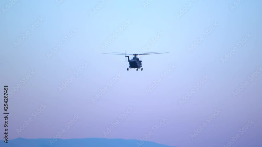 A black helicopter in flight, above Sofia, descending in preparation to land on the airport A black helicopter in flight, above Sofia, descending in preparation to land on the airport