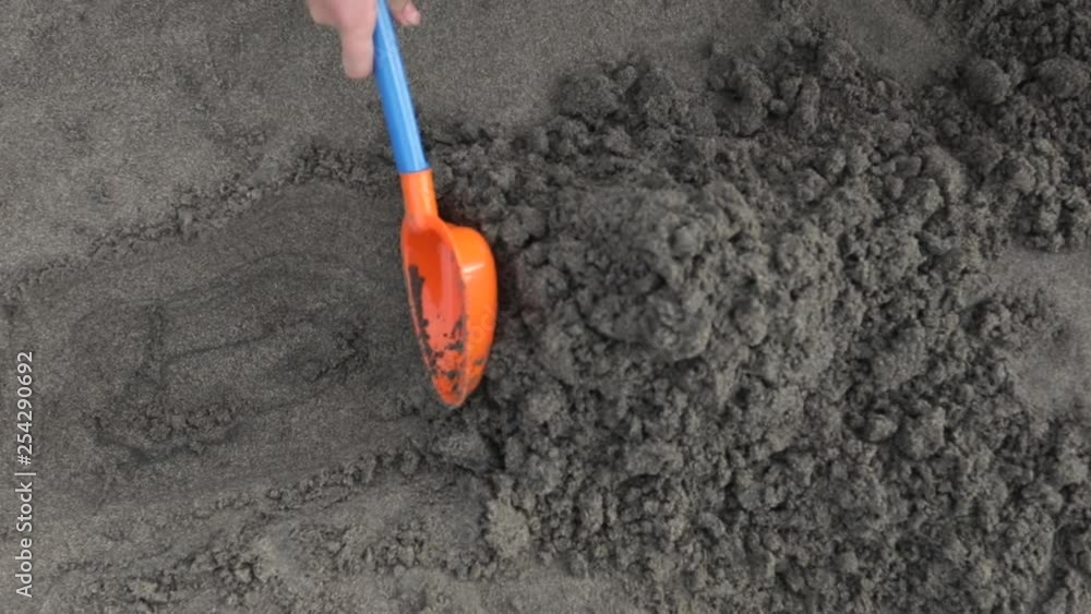 digging in the sand with a toy beach shovel. digging in the sand with a toy beach shovel.
