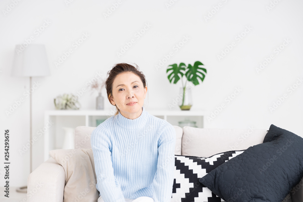 部屋でリラックスするシニア女性