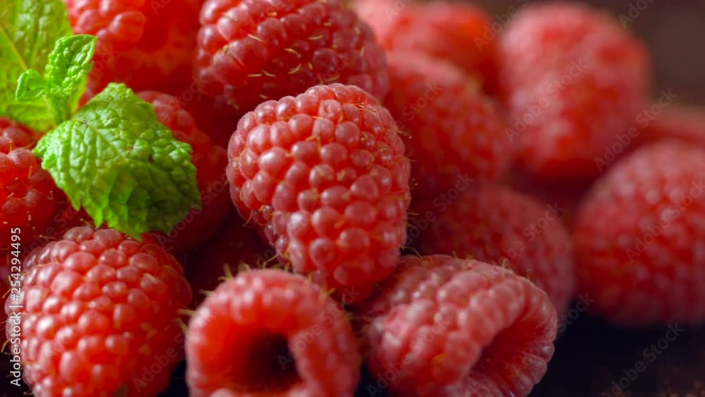 Macro closeup of rotating summer fruit raspberries on wooden table. Macro closeup of rotating summer fruit raspberries on wooden table.