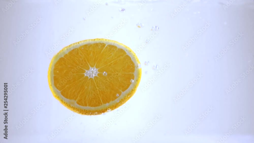 Orange slices fall into water in slow motion Orange slices fall into water in slow motion