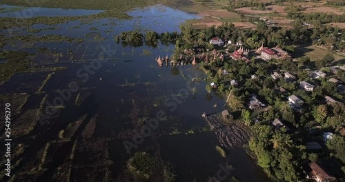 Shan State, Myanmar. Aerial view of a traditional long tail boat approaching an ancient flooded pagodas of Samkar village. photo