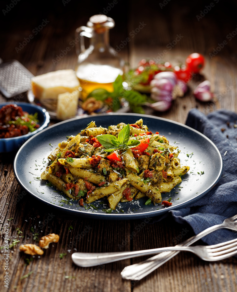 Penne pasta with spinach, sun dried tomatoes and chicken, sprinkled with parmesan cheese and fresh parsley Penne pasta with spinach, sun dried tomatoes and chicken, sprinkled with parmesan cheese and fresh parsley