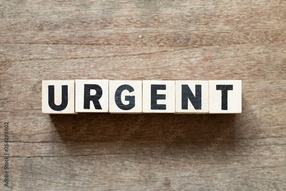 Letter block in word urgent on wood background Letter block in word urgent on wood background
