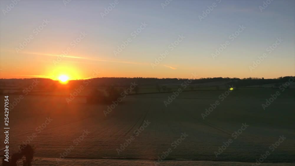 Golden sun rise from Leicestershire Manor House overlooking field with sun rising over the horizon Golden sun rise from Leicestershire Manor House overlooking field with sun rising over the horizon