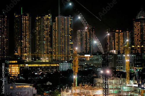 24 hours non stop construction site at night. Ground breaking construction of MRT or Mass Rapid Transit Station with lots of tower crane