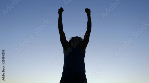 Silhouette of a victorious man at sunset.