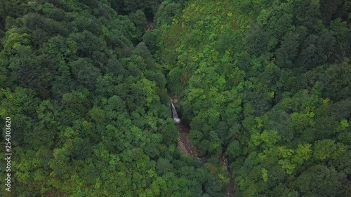 4K aerial drone pull back shot, zooming in a streaming waterfall among amazingly green trees, idyllic scene of nature, in Akyamac, Rize Province, Turkey photo