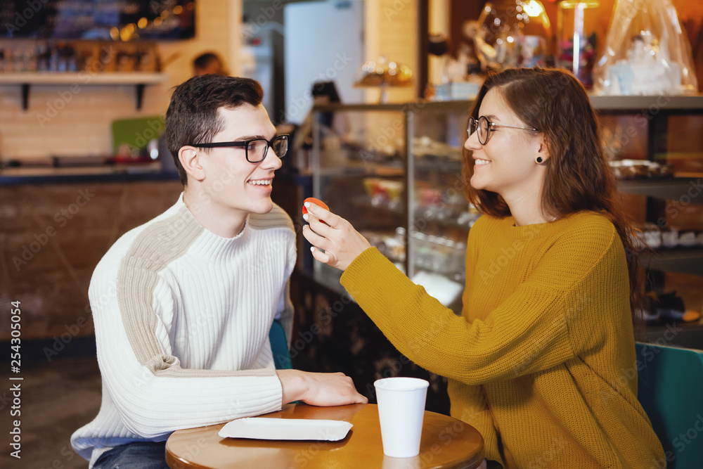 Two cute young men and a girl in a cafe. Two cute young men and a girl in a cafe.