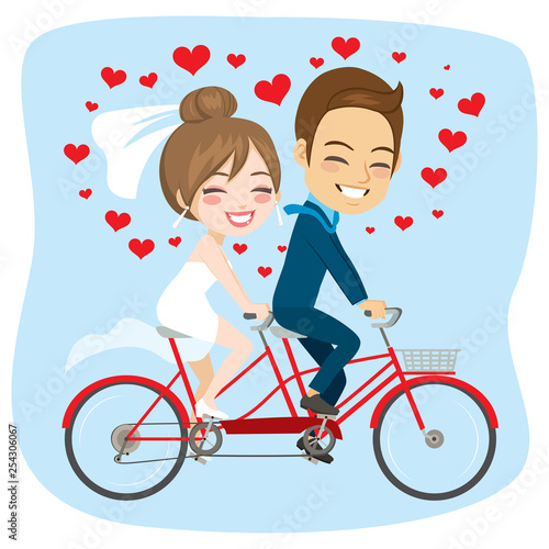 Young newlywed couple riding on tandem bicycle just married concept