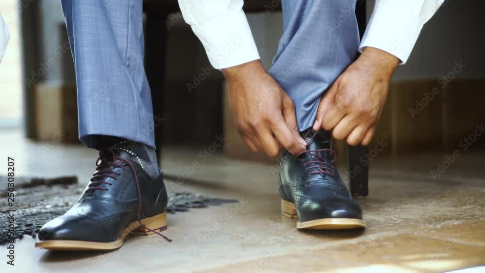 Groom putting on shoes at his wedding. Groom putting on shoes at his wedding.