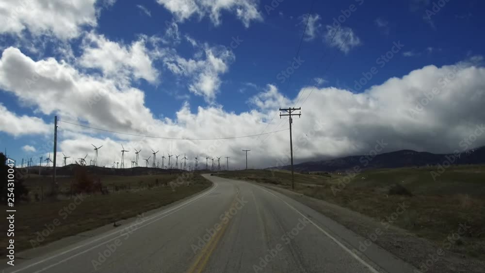 California Wind Turbines around Tehachapi in late winter with some snow on the ground. Multiple wind turbines, large and small, some not working amid a forest of power lines and grids. California Wind Turbines around Tehachapi in late winter with some snow on the ground. Multiple wind turbines, large and small, some not working amid a forest of power lines and grids.