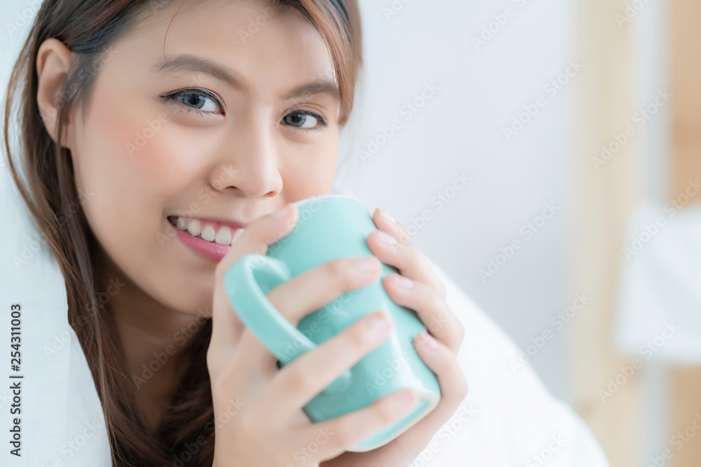 beautiful asian woman enjoy morning time with hot drink in bedroom with window light beautiful asian woman enjoy morning time with hot drink in bedroom with window light