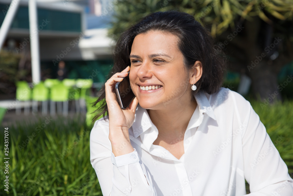 Happy attractive woman talking on mobile phone outdoors Happy attractive woman talking on mobile phone outdoors