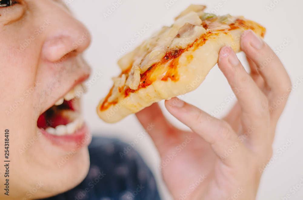 Close up portrait of excited happy hungry young man eating a piece of pizza, focus pizza Close up portrait of excited happy hungry young man eating a piece of pizza, focus pizza