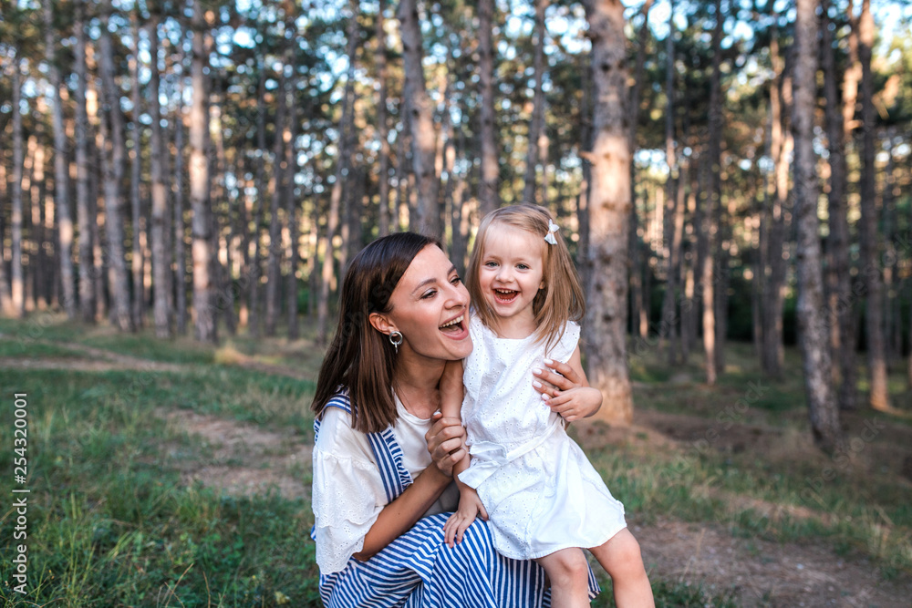 Fototapeta premium Happy mother and daughter singing together outdoors.