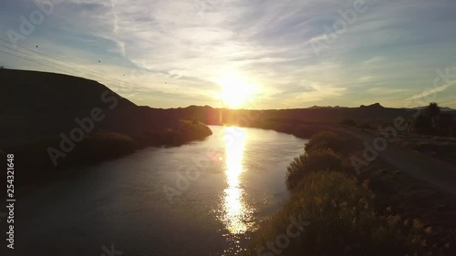 Aerial dolly forwards, flying over the all American Canal towards the sunset.