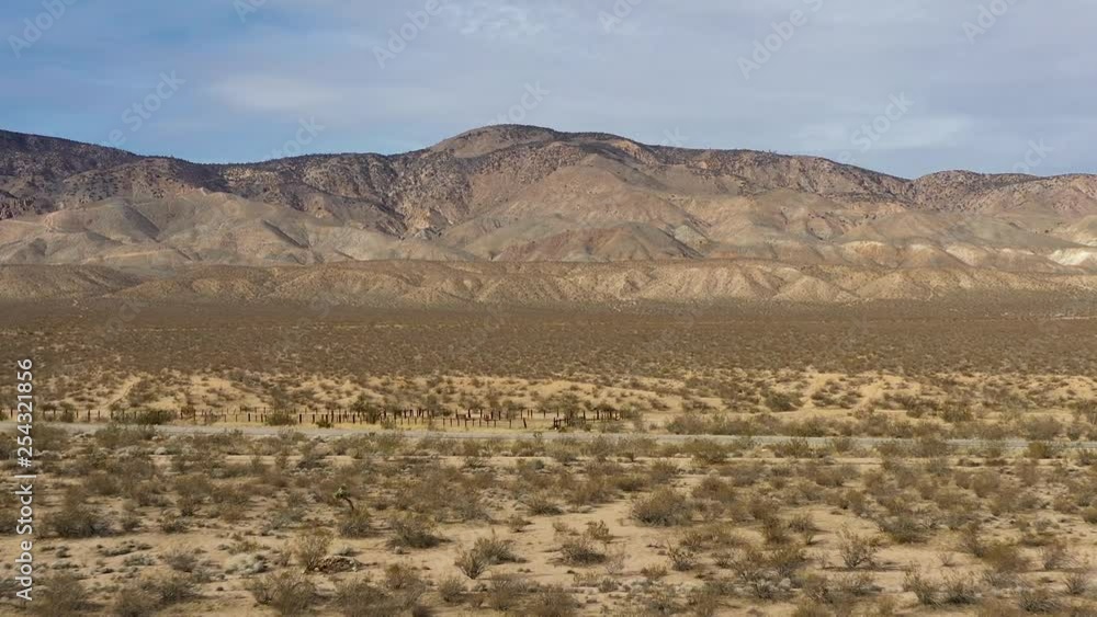 Aerial Dolly Zoom emphasizing vastness of Mojave Desert with mountain background