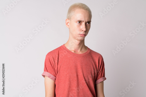 Face of young serious androgynous man thinking