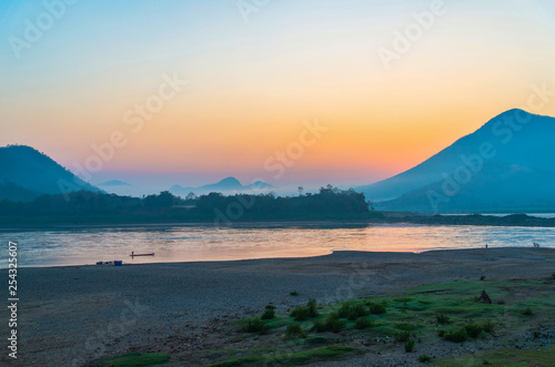 Landscape river beach fisherman on fishing boat beautiful sunrise and colorful sky