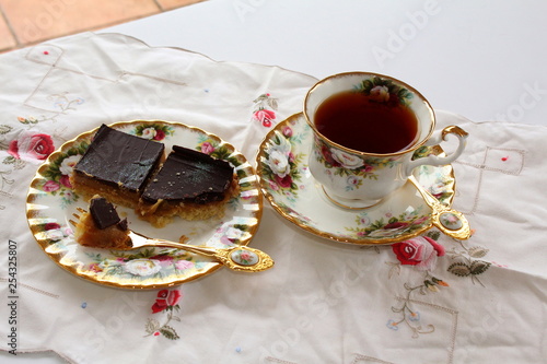 Rooibos tea and millionaire's shortbread in fancy bone china on the patio., with space top right for text.