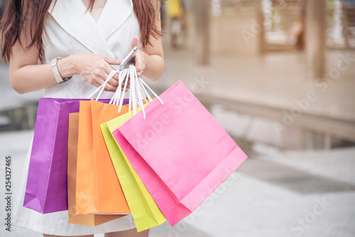 Shopaholic Women holding shopping bags ,money ,credit card person at shopping malls.Fashionable Woman love online website with sales tag on black Friday. E-commerce fashion digital marketing lifestyle