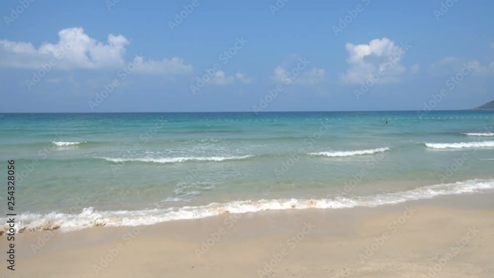 Waves rolling on tropical beach, paradise white sand and blue sea and white fluffy clouds sky horizon. Waves rolling on tropical beach, paradise white sand and blue sea and white fluffy clouds sky horizon.