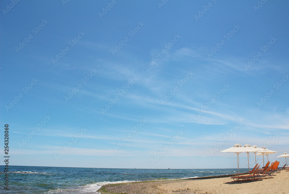 White beach umbrella and sunbed on the beautiful sea in Sunny weather. Bright summer Wallpaper for your computer.