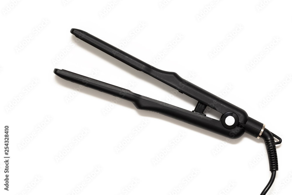 Electric black hair iron with ceramic plates, on white background. Top view. Electric black hair iron with ceramic plates, on white background. Top view.