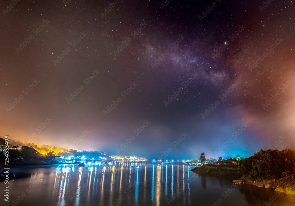 The Milky Way is above the old wooden bridge (Mon Bridge), Kanchanaburi province, Thailand.
