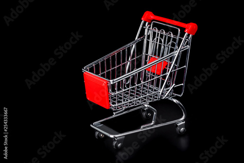 Toy shopping cart isolated on black