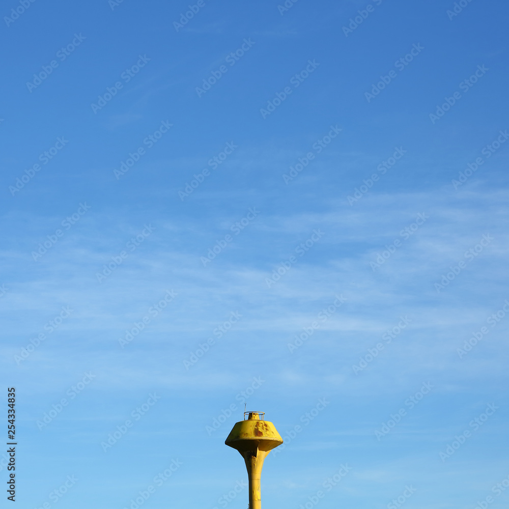 minimal image, yellow water tank with clear blue sky background