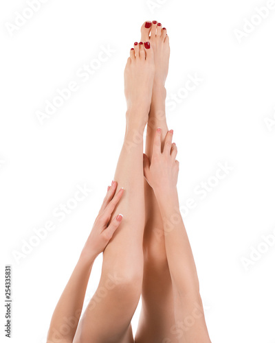 Fototapeta Naklejka Na Ścianę i Meble -  Long female barefoot legs raise up, classic red pedicure, isolated on white. Well groomed skin.