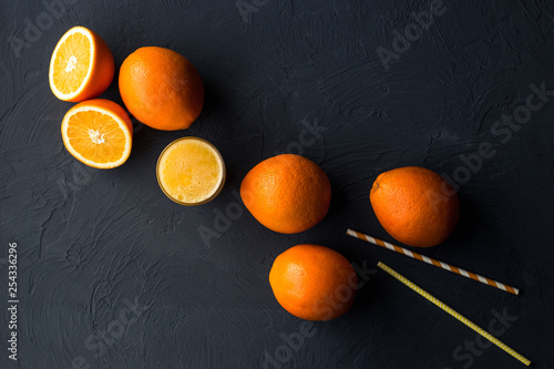 Fresh orange juice and fresh fruit oranges on a black background