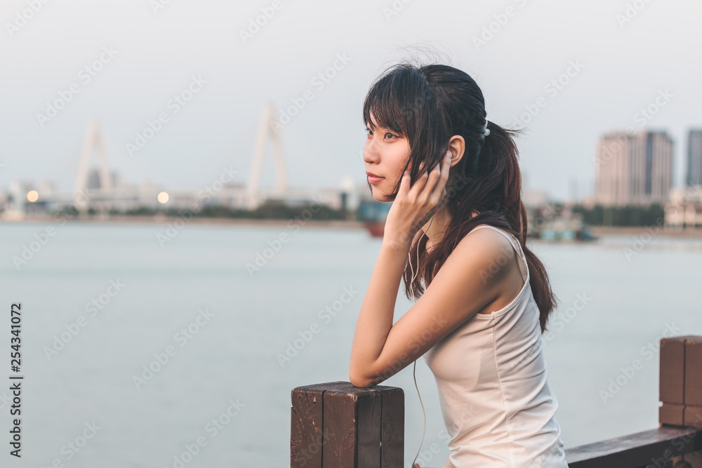 young woman listen music by seaside