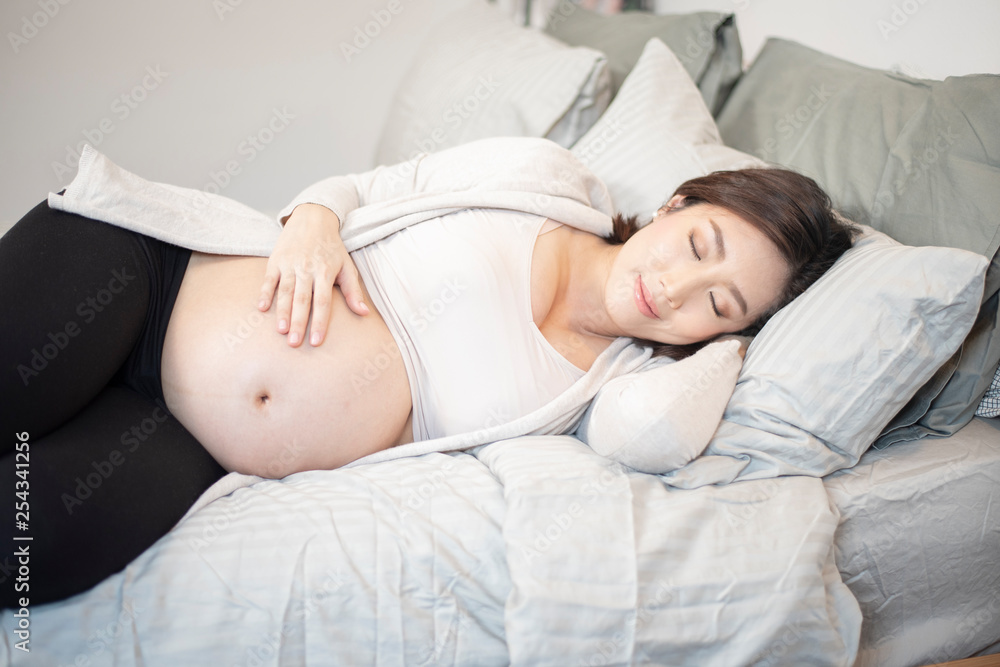 Beautiful asian pregnant woman is sleeping on bed Beautiful asian pregnant woman is sleeping on bed