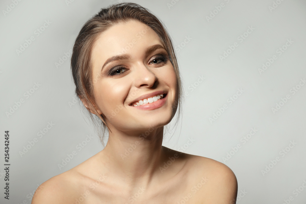 Portrait of beautiful young woman on grey background Portrait of beautiful young woman on grey background