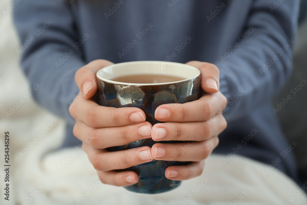 Young woman drinking hot tea at home, closeup Young woman drinking hot tea at home, closeup