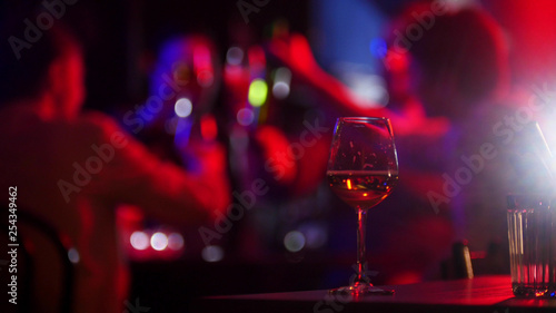 Bar with neon lighting. A person holding a glass of beer