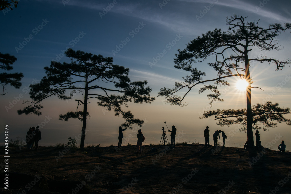 Silhouettes of tourist team on mountain peak