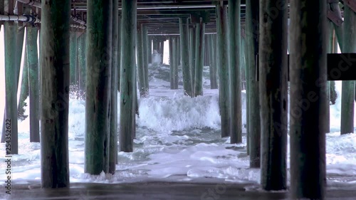 Waves crashing underneath a pier photo